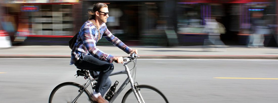 Hombre circulando en una bici por una ciudad