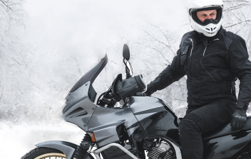 Motero sobre su moto en un paisaje nevado