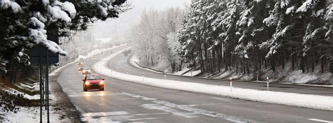 Coches circulando por carretera llena de nieve