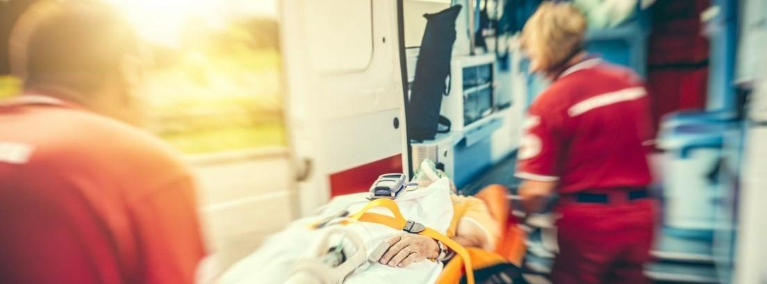 Personal sanitario introduciendo a un hombre en una ambulancia
