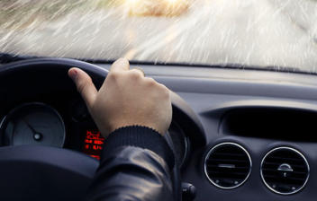 Conductor dentro de un coche en un día lluvioso