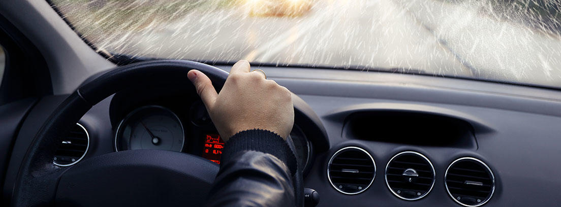 Conductor dentro de un coche en un día lluvioso