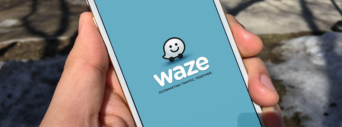 Conductor enseña el móvil con la aplicación Waze abierta en el teléfono.