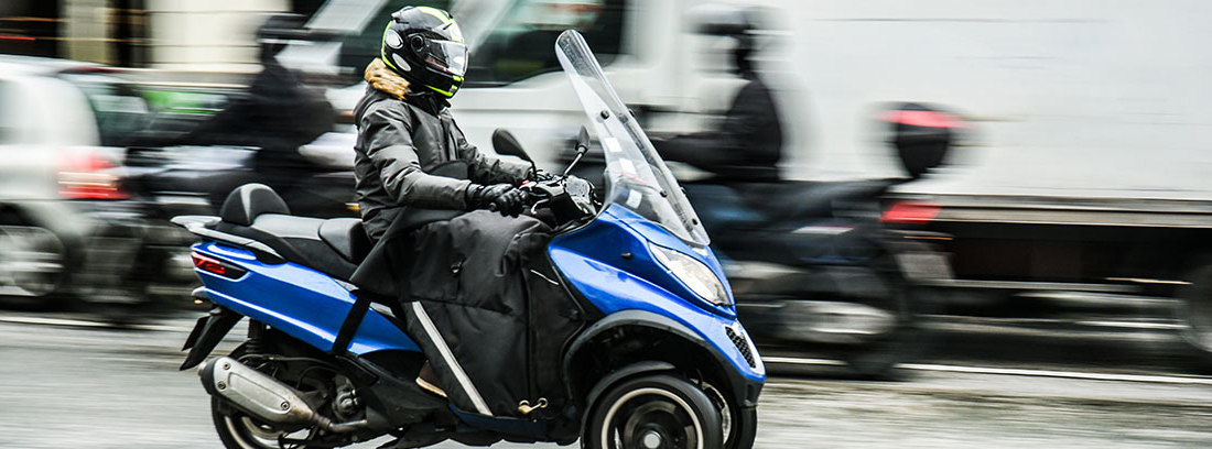 Persona con casco sobre una moto de tres ruedas
