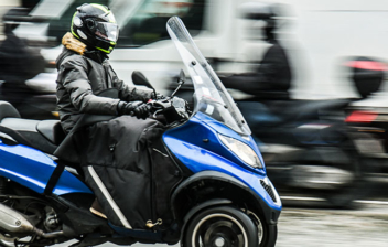 Persona con casco sobre una moto de tres ruedas