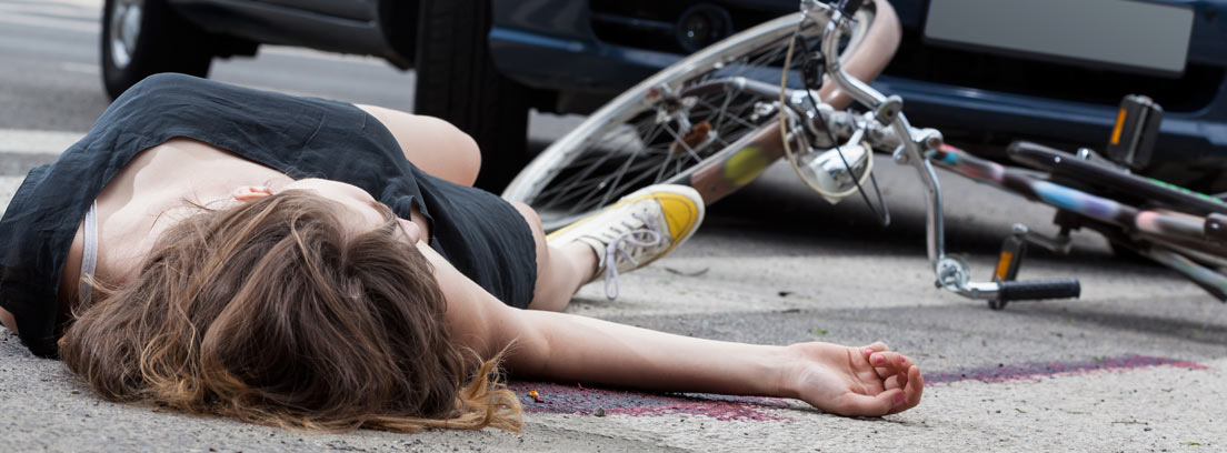 Ciclista en el suelo tras sufrir un atropello de un coche