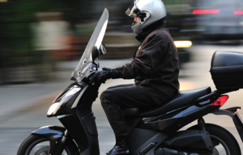 hombre moviéndose con su scooter por la ciudad