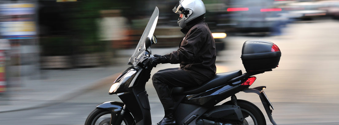hombre moviéndose con su scooter por la ciudad