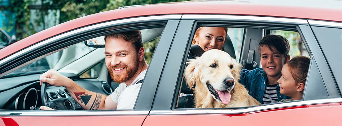 Familia con perro viajando en coche
