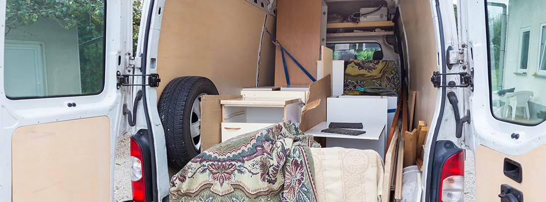 Interior de furgoneta con cosas cargadas y revestimiento de madera
