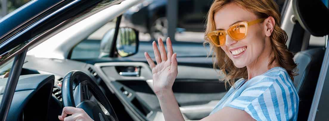 Mujer haciendo una señal con las manos al conducir