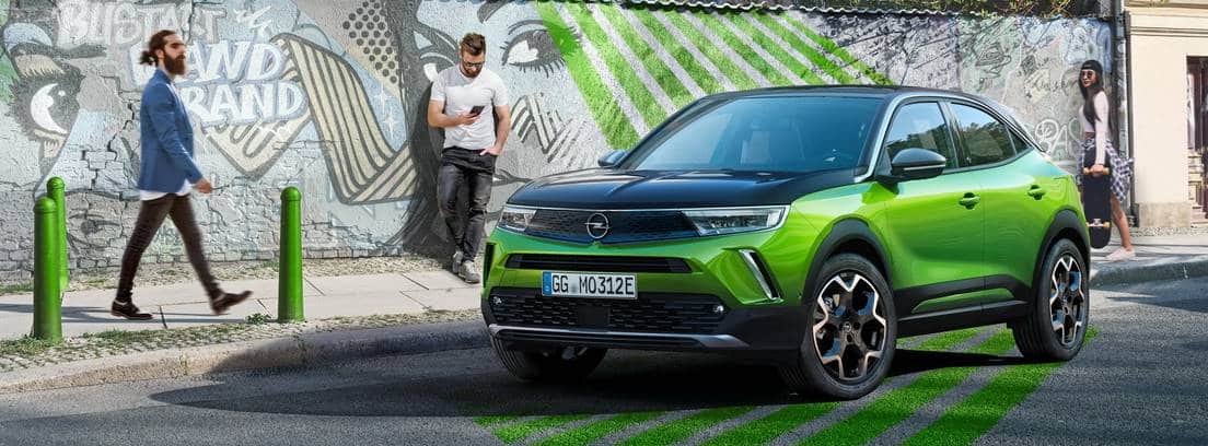 Opel Mokka-e verde aparcado en una calle con detalles destacados del mismo color que el coche
