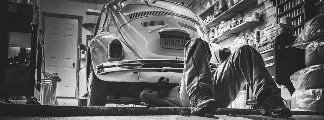 Hombre restaurando un coche Volkswagen Escarabajo clásico