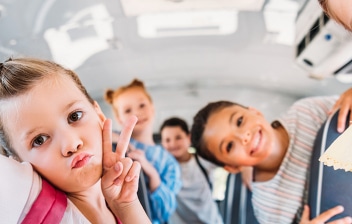 Niños sonrientes dentro de un autobús escolar