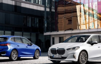 Dos coches BMW Active Tourer serie 2 aparcados en la calle, uno azul y otro blanco