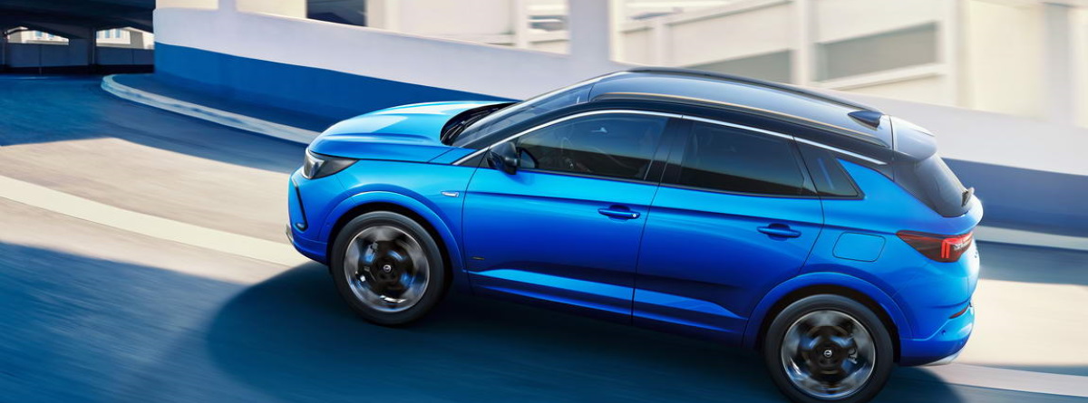 Opel Grandland azul circulando por la carretera, visión lateral