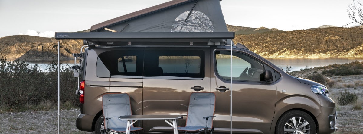 Toyota ProAce Verso Camper estacionado con el toldo y dos silla y mesa  
