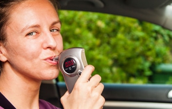 Mujer usando un alcoholímetro antiarranque en un coche