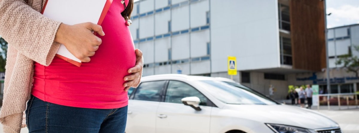Mujer embarazada hacia el coche