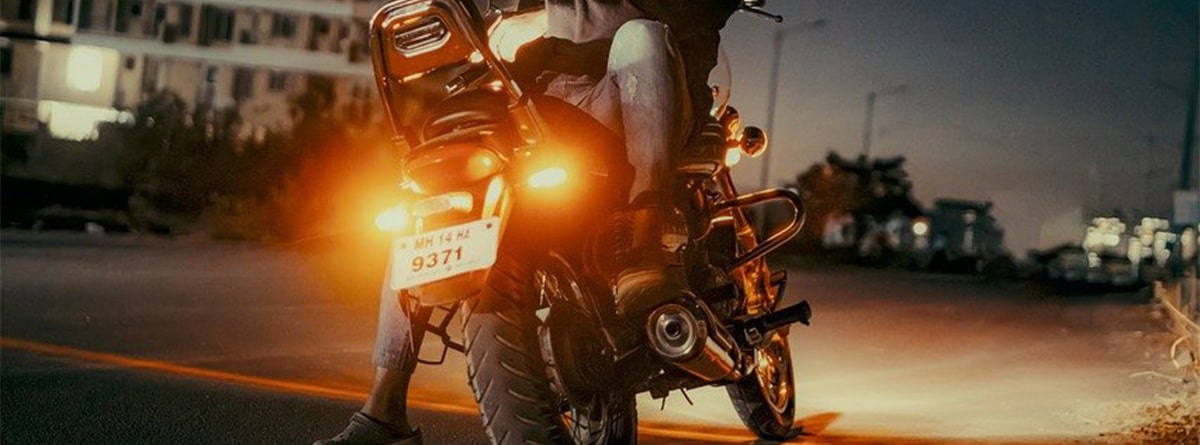 Hombre sentado en su moto con catadióptricos