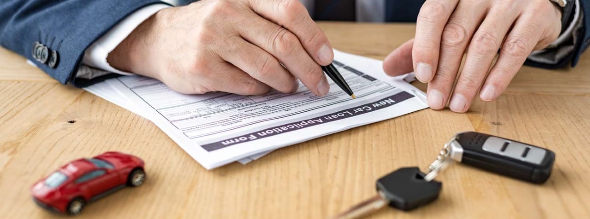 Persona firmando un contrato de compra venta de un coche