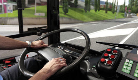 Conductor profesional visión de volante de un autobús con unas manos cogiéndolo