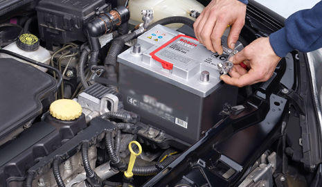 Mecánico realizando el mantenimiento de la batería del coche Mecánico realizando el mantenimiento de la batería del coche