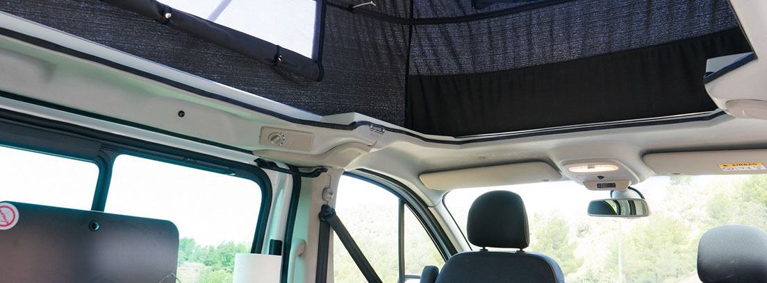 Interior con techo elevado de una camper de Nissan