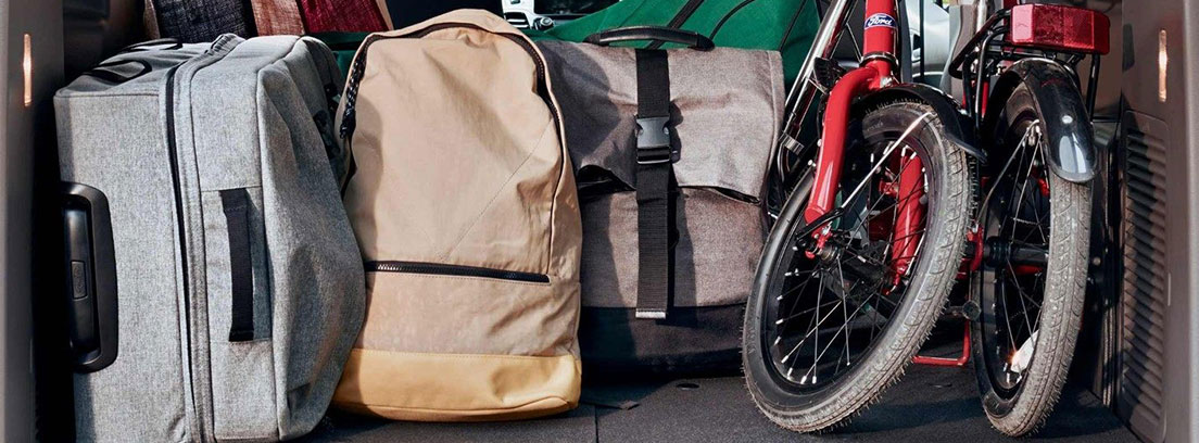 Ford Tourneo Connect 2018: configuración de los asientos Vista interior del Ford Tourneo Connect 2018 desde el maletero, con maletas, mochilas y una bicicleta plegada.
