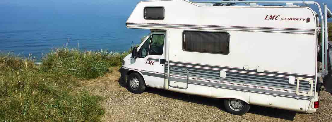 rutas en autocaravana por españa Autocaravana blanca LMC Liberty aparcada en un acantilado sobre el mar