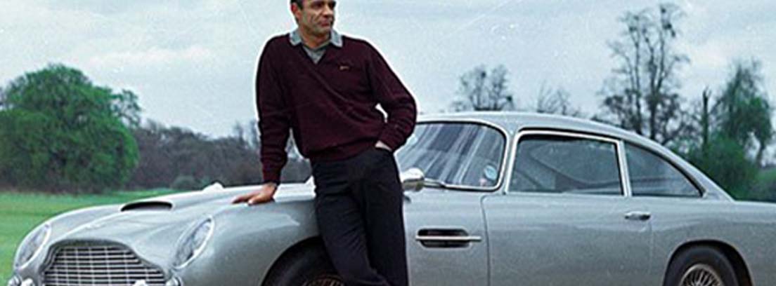 Sean Connery apoyado sobre un Aston Martin DB5