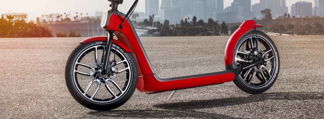 Patinete eléctrico rojo con edificios altos al fondo