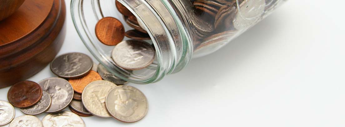 Mazo de madera junto a bote con monedas