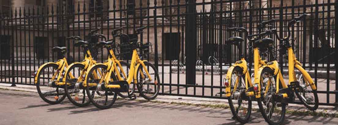 Varias bicis amarillas en una verja en ciudad