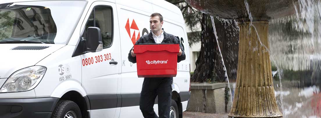 Hombre con caja roja junto a furgoneta