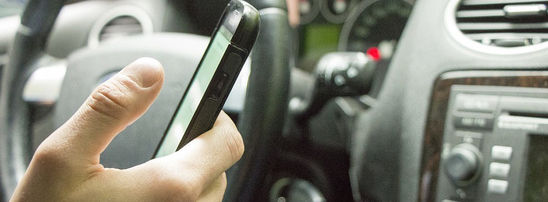 persona usando el teléfono móvil en el coche