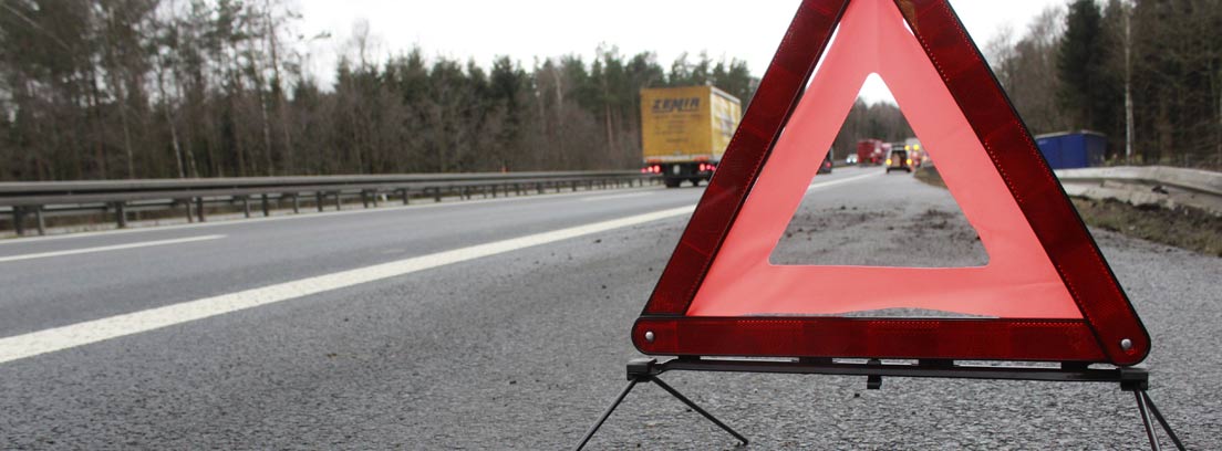Triangulo de señalización de coche averiado en una carretera