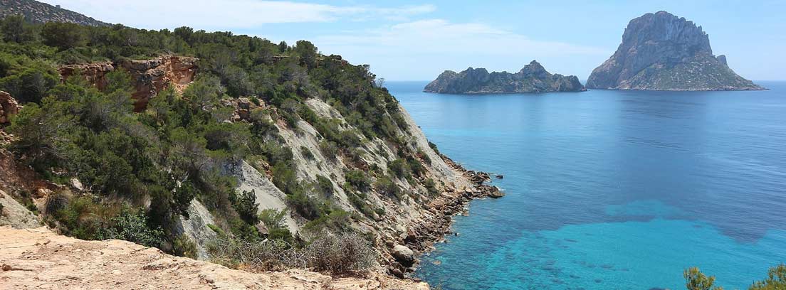 Vista la isla de Es Vedra en Ibiza desde un pequeño acantilado.