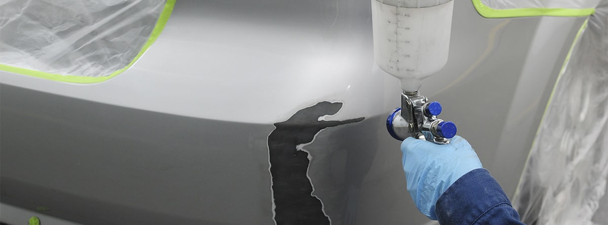 Hombre pintando un coche con spray